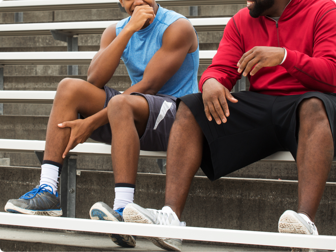Two men sitting at outdoor bleachers