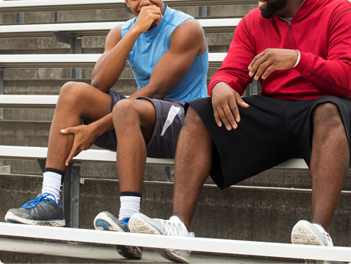 Two men sitting at outdoor bleachers
