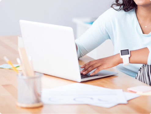 Person using laptop with smartwatch