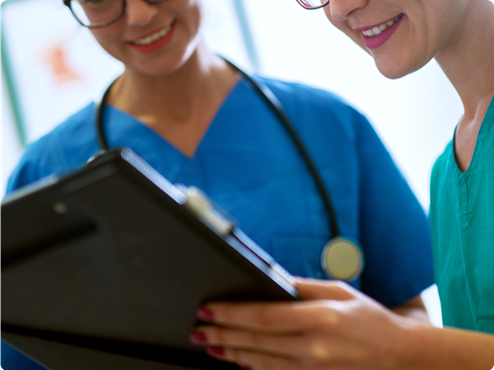 Smiling nurses checking a clipboard