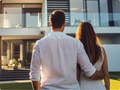 Couple standing in front of their home